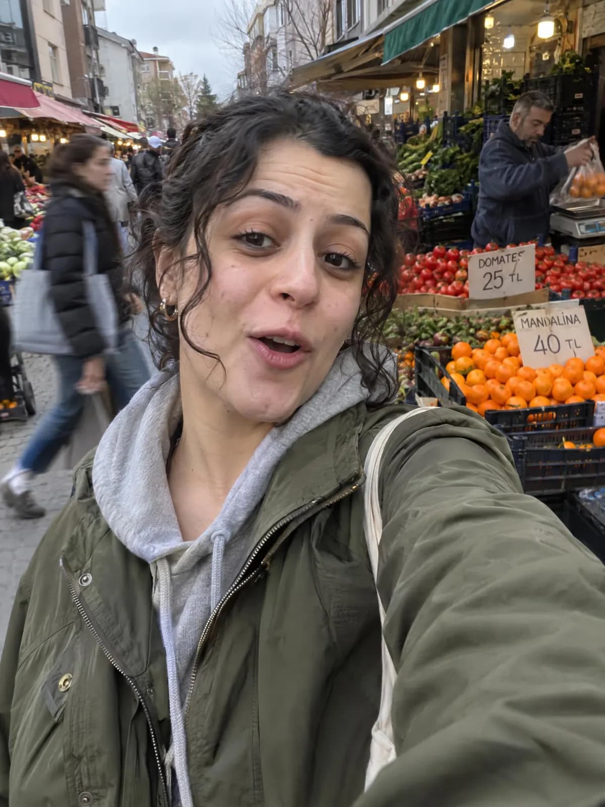 Kendyo demosunda sebze meyve pazarında selfie çeken bir kadın